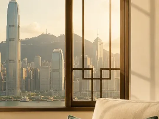 香港家中客廳一角，窗外是維港景色，茶几上放著茶具